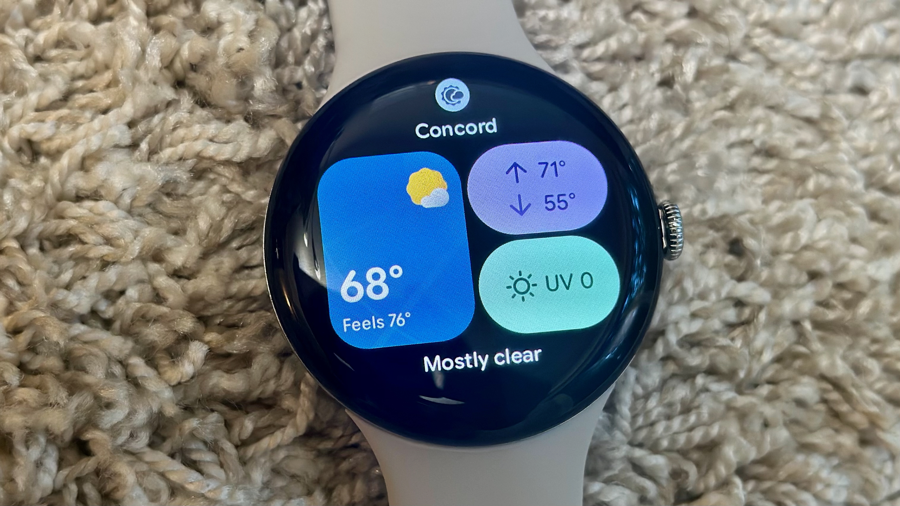 The Weather tile on the Google Pixel Watch 4 showing temperature, high/low, and UV data.