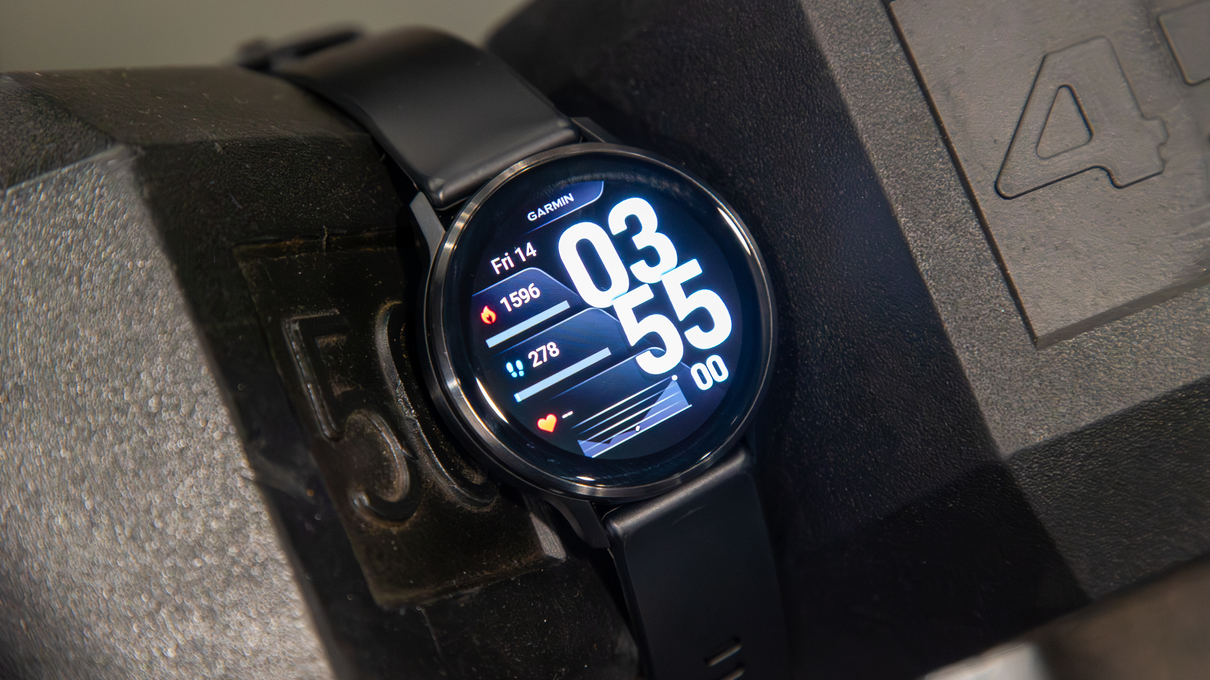 Garmin Venu 4 in between two dumbbells