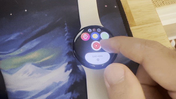 A GIF showing the Pixel Watch 4 app drawer with a finger scrolling it up and down, revealing the "List View" Edge button.