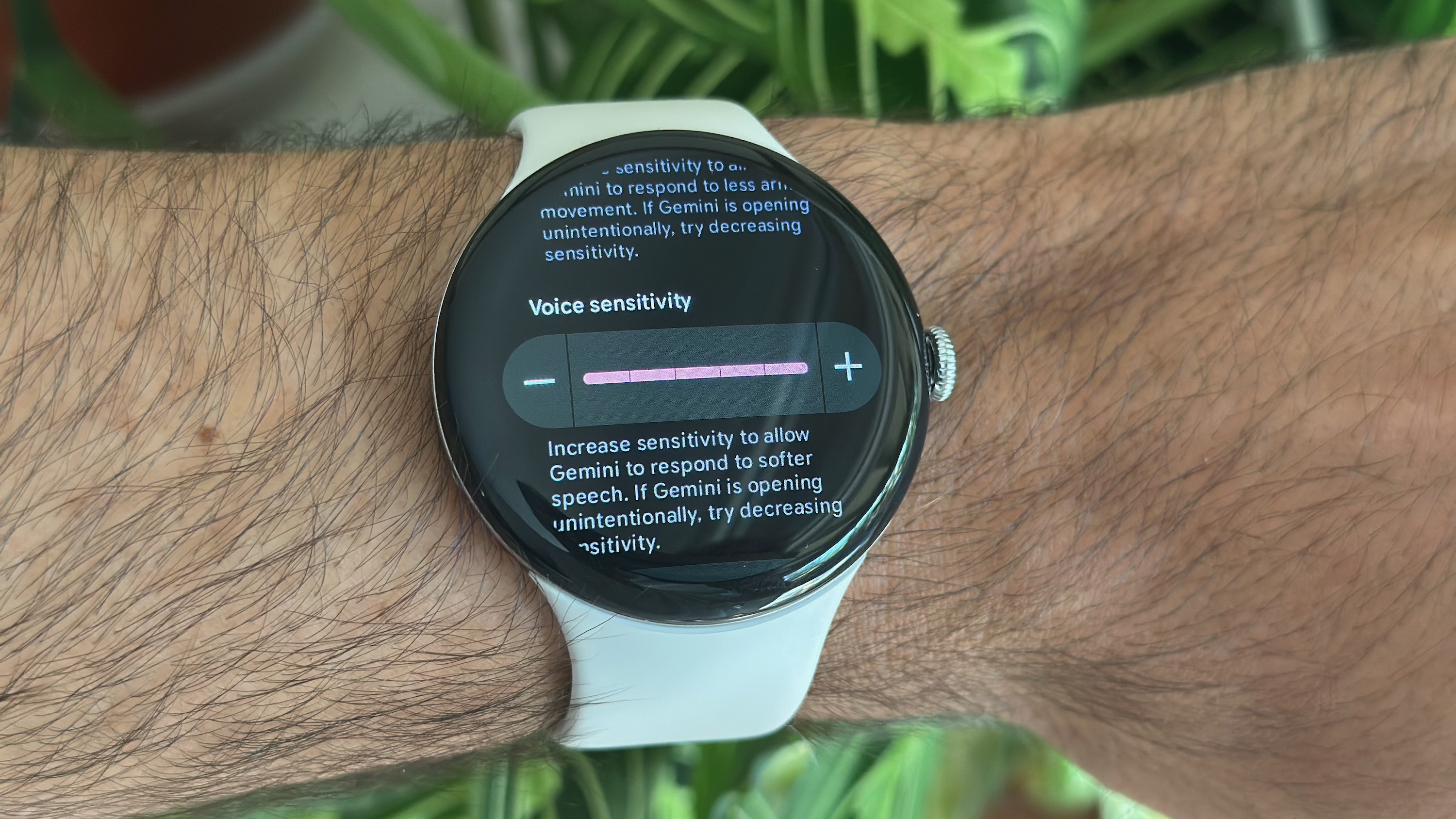 Μια φωτογραφία του Google Pixel Watch 4 στον καρπό ενός άνδρα, που δείχνει τη ρύθμιση ευαισθησίας φωνής που έχει οριστεί στο 5/5 για τη λειτουργία Gemini Raise to Talk.