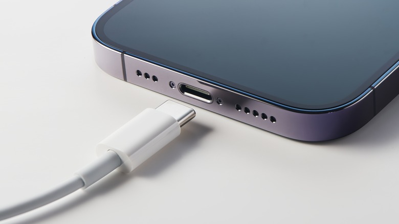 Κοντινό πλάνο της θύρας φορτιστή iPhone με καλώδιο κοντά της