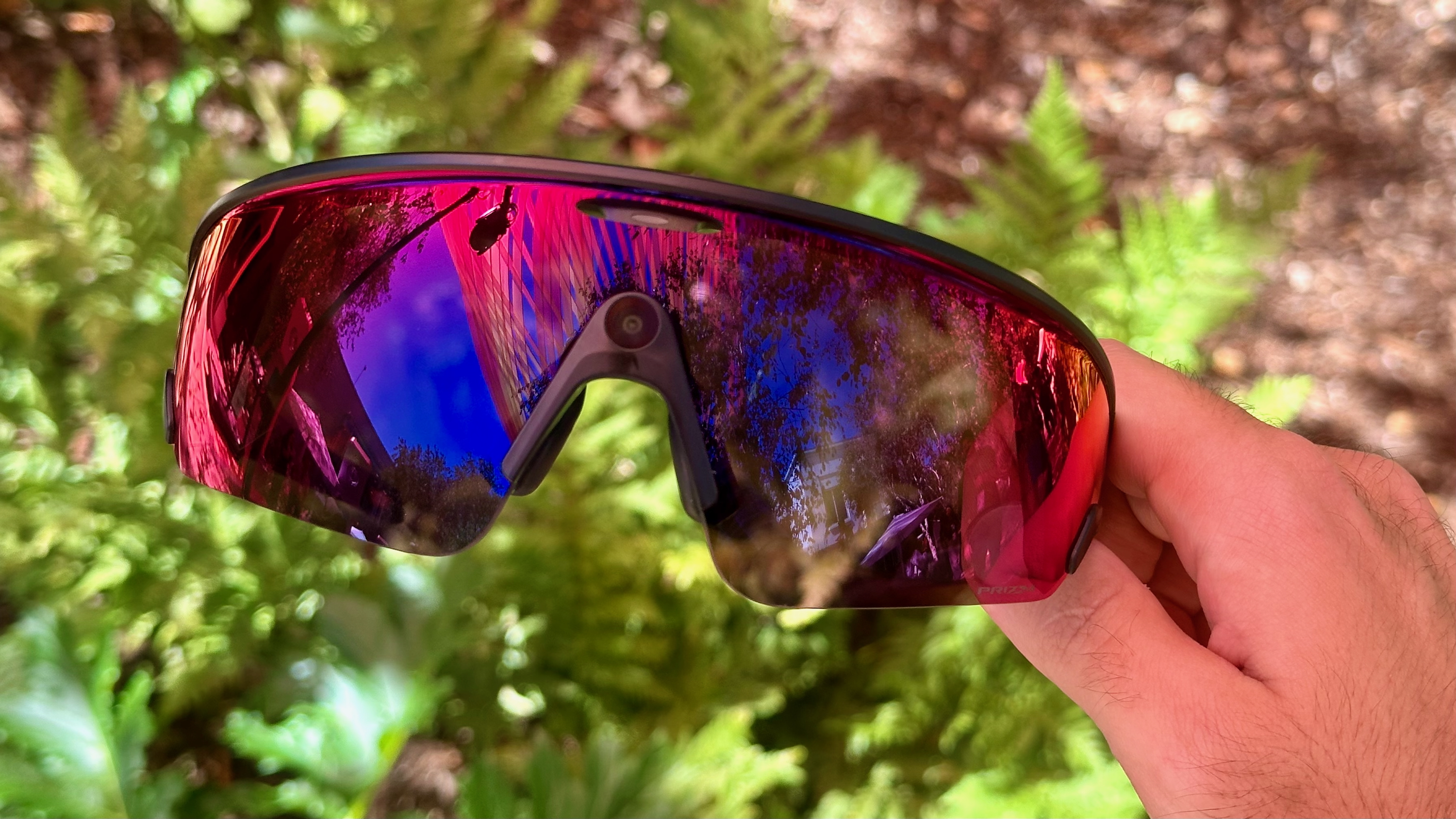 Φωτογραφία με τα έξυπνα γυαλιά Oakley Meta Vanguard κρατημένα στο χέρι.