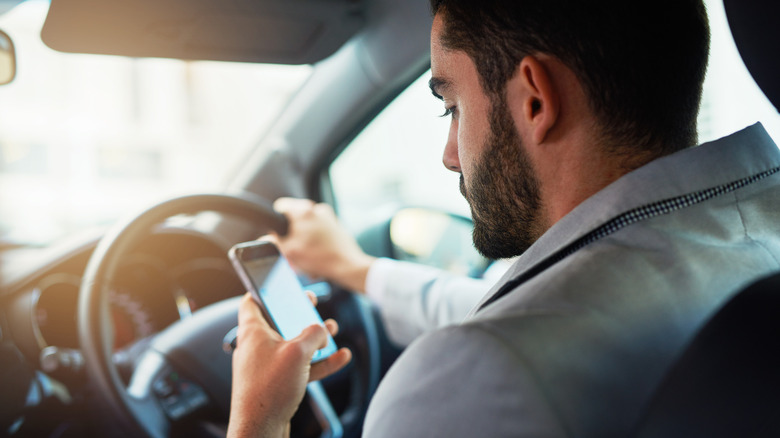 Άτομο που χρησιμοποιεί το τηλέφωνό του ενώ οδηγεί