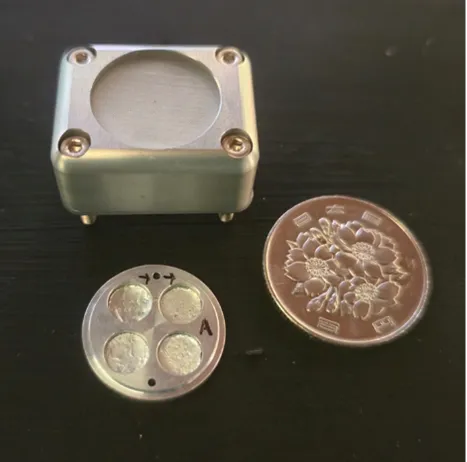 Η μονάδα έκθεσης στο διάστημα που χρησιμοποιήθηκε για το πείραμα δίπλα σε ένα νόμισμα 100 γιεν για κλίμακα.