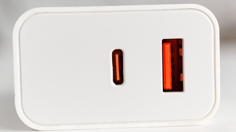 Μια κοντινή φωτογραφία ενός μπλοκ φόρτισης USB που δείχνει μια πορτοκαλί θύρα USB Type-A και μια πορτοκαλί θύρα USB Type-C.