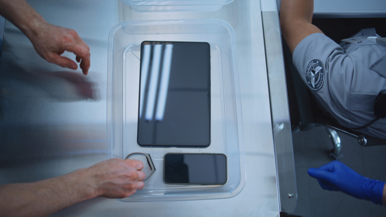 Άτομο που βάζει ηλεκτρονικό στον κάδο στη γραμμή TSA