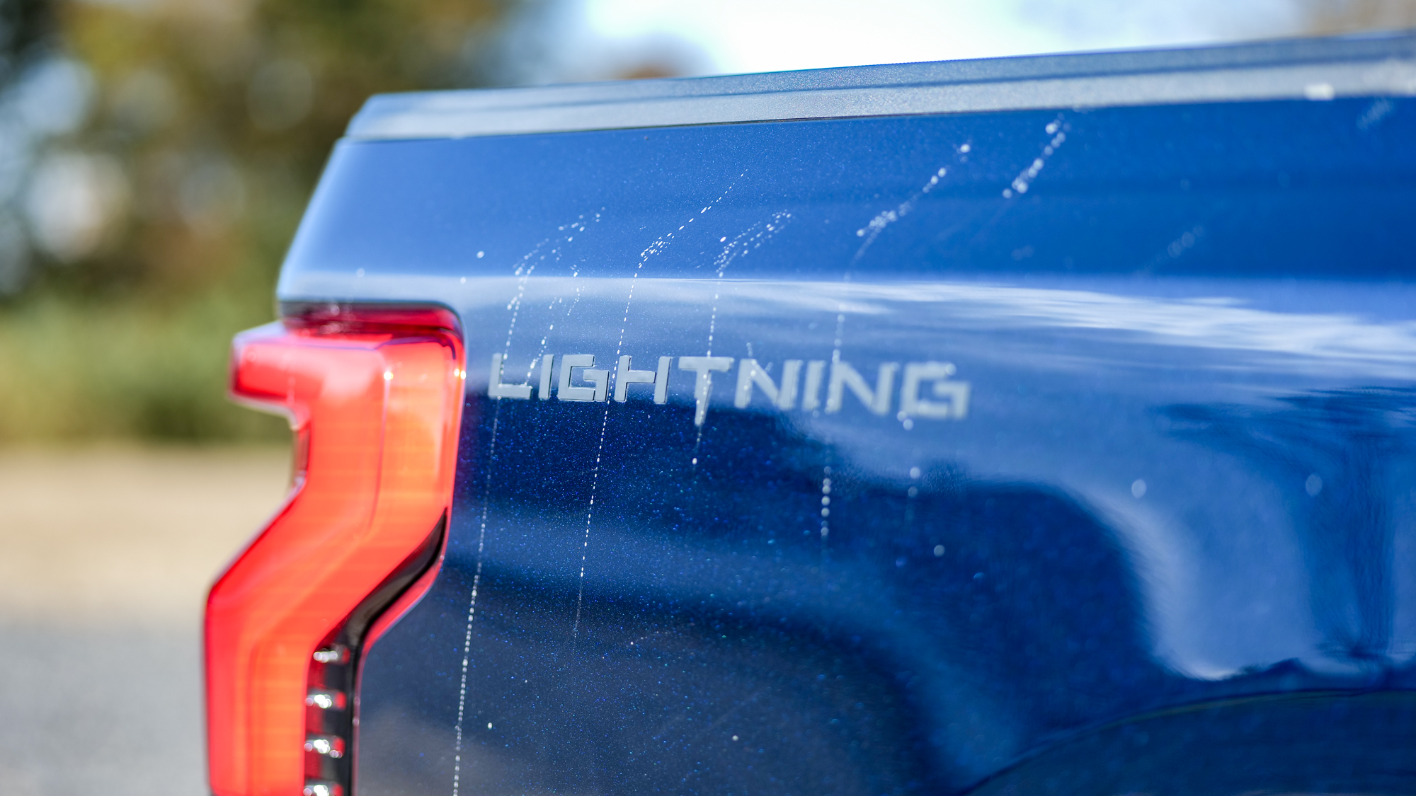 Δοκίμασα το Ford F-150 Lightning για μια εβδομάδα – Αυτό το αμιγώς ηλεκτρικό pickup θα σας αφήσει άφωνους! Κινηματογράφηση σε πρώτο πλάνο με λογότυπο Ford F-150 Lightning 2025.