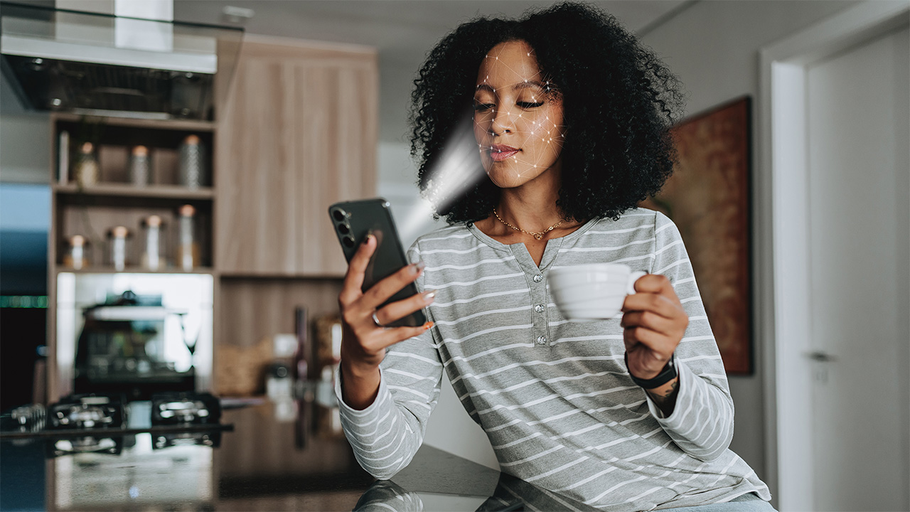 «Σοκ: Η απαγόρευση των social media στην Αυστραλία μπορεί να φέρει περισσότερα προβλήματα απ' όσα νομίζεις!» Το άτομο, καθόταν σε μια κουζίνα κρατώντας μια κούπα, σαρώνοντας το πρόσωπό του με το smartphone του