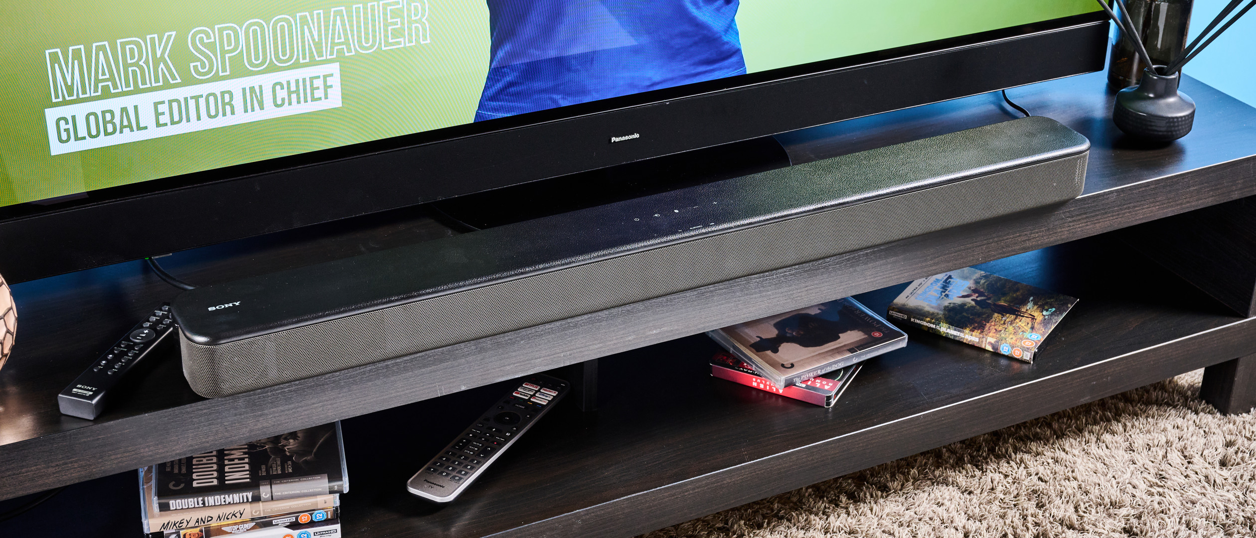 το sony ht-s100f ή το sony ht-sf150 στο Ηνωμένο Βασίλειο, μια μαύρη μπάρα ήχου με κουμπιά στο επάνω μέρος, ένα τηλεχειριστήριο, φωτογραφημένη με τηλεόραση panasonic