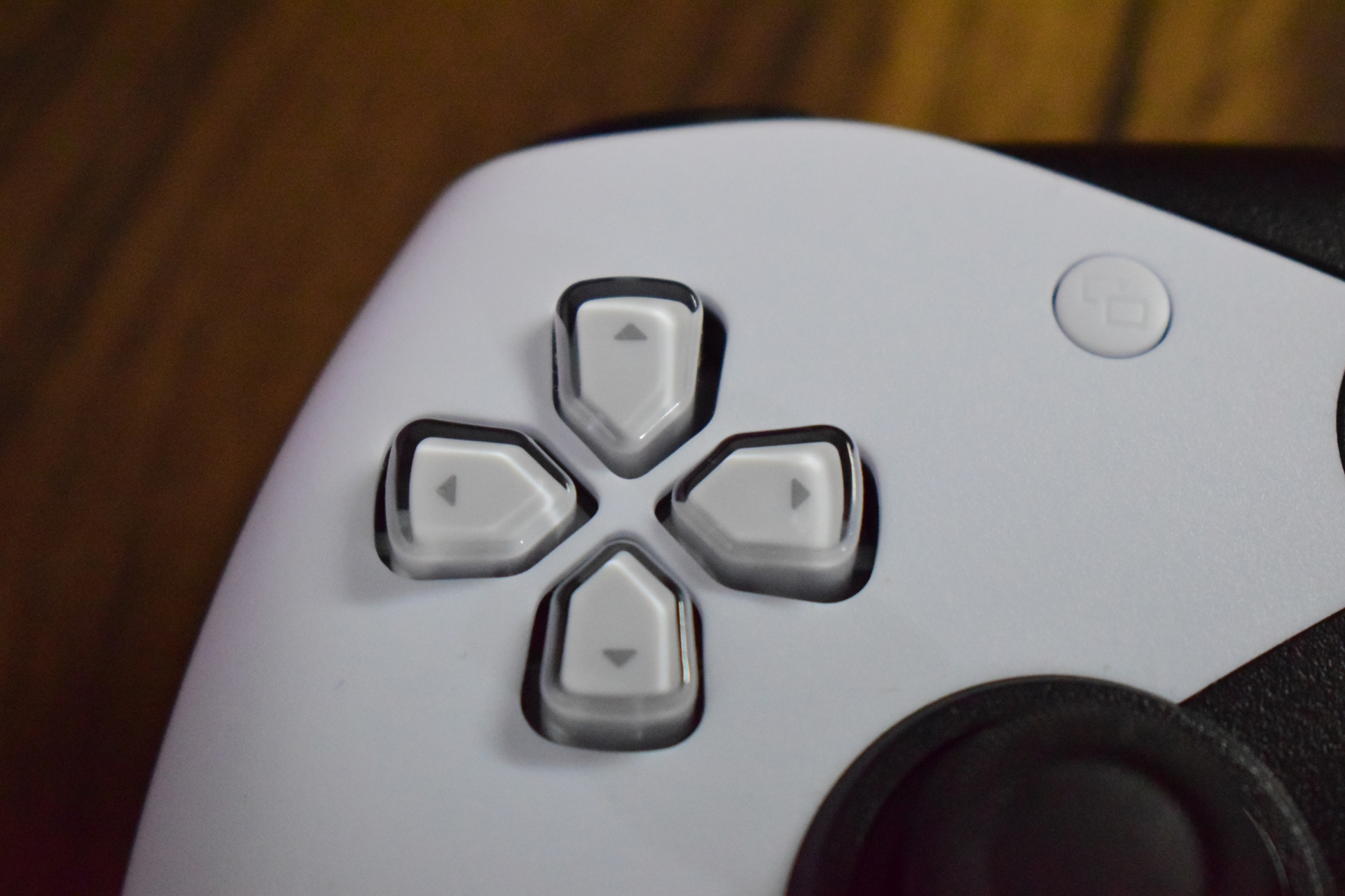 Ικανοποιητικός ελεγκτής προϋπολογισμού για PC και Xbox Κοντινό πλάνο των κουμπιών κατεύθυνσης σε ένα χειριστήριο Sony PlayStation 5 DualSense.