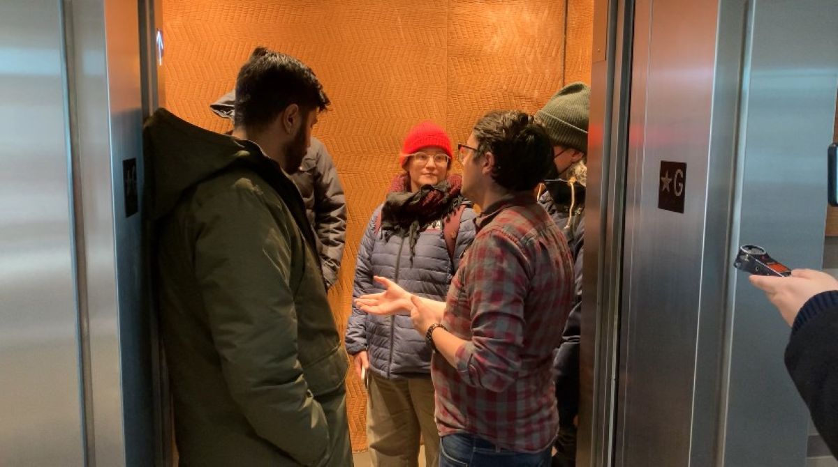 CWA Canada and Local Toronto Game Devs Protest at Rockstar Toronto in Solidarity with 34 Fired Workers Several people wearing winter clothing are having a conversation inside an elevator with the door open at a floor labeled '*G'.