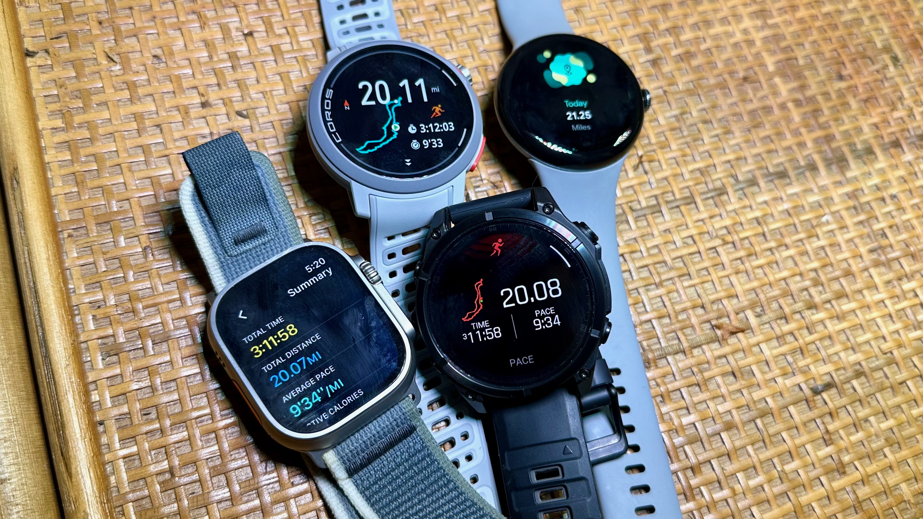 Το Apple Watch Ultra 2, το Garmin Fenix ​​8, το COROS PACE Pro και το Google Pixel Watch 3 που κάθονται μαζί σε ένα ράφι, όλα δείχνουν μια περίληψη μετά τον αγώνα για έναν αγώνα 20 μιλίων εκείνη την ημέρα.