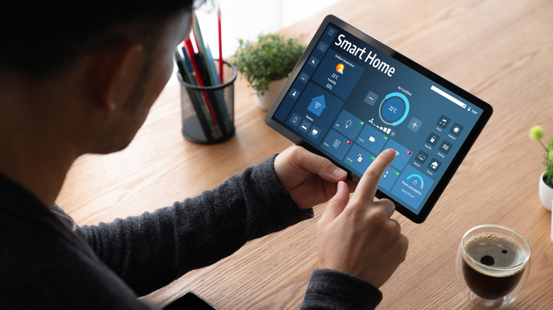Ένα άτομο που στήνει ένα σύστημα έξυπνου σπιτιού σε ένα tablet.