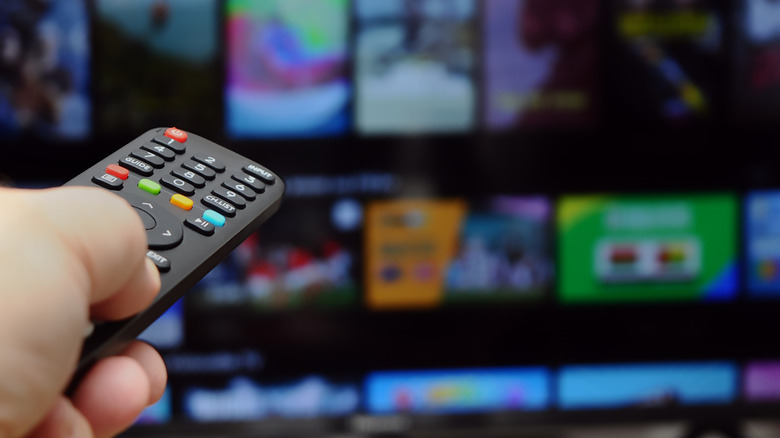 Τηλεχειριστήριο σε πρώτο πλάνο με διεπαφή έξυπνης τηλεόρασης θολή πίσω.