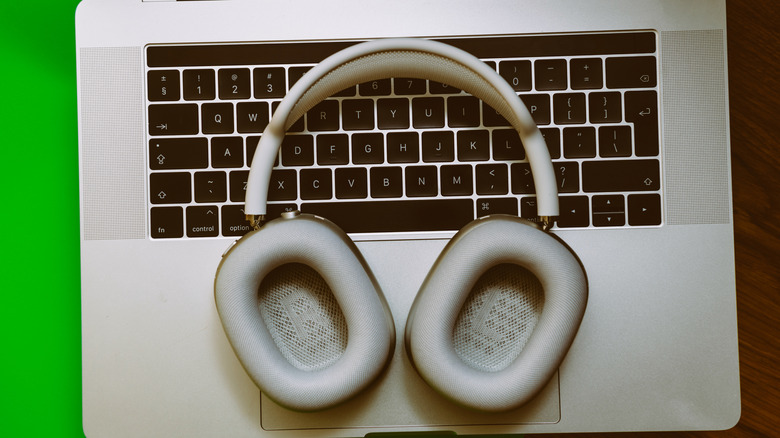 Το AirPods Max στηρίζεται πάνω σε ένα πληκτρολόγιο φορητού υπολογιστή.