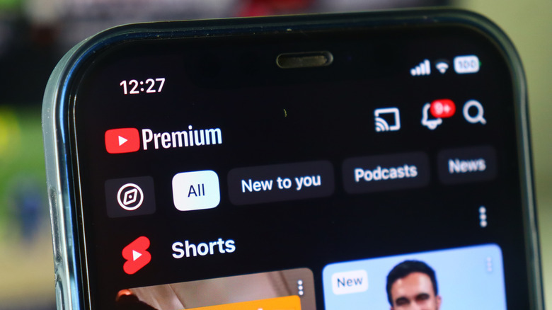 Λογότυπο YouTube Premium και ροή βίντεο σε οθόνη smartphone