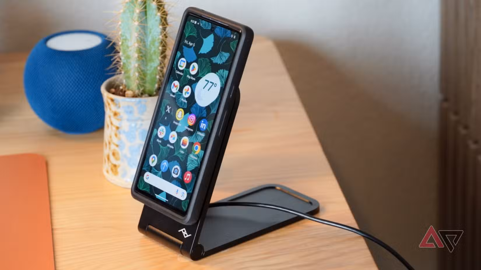 Πλαϊνή όψη του ασύρματου φορτιστή Peak Design που φορτίζει ένα Pixel 7a.