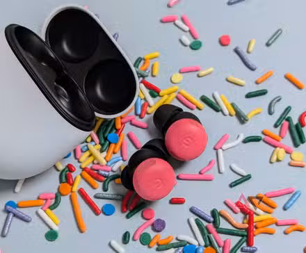 Αυτό το βασικό εργαλείο της Google μπορεί πλέον να κατανοήσει την αργκό και τους ιδιωματισμούς Ανοιχτή θήκη Google Pixel Buds Pro 2 με μπουμπούκια παιώνιας στο τραπέζι που περιβάλλεται από ψεκασμούς