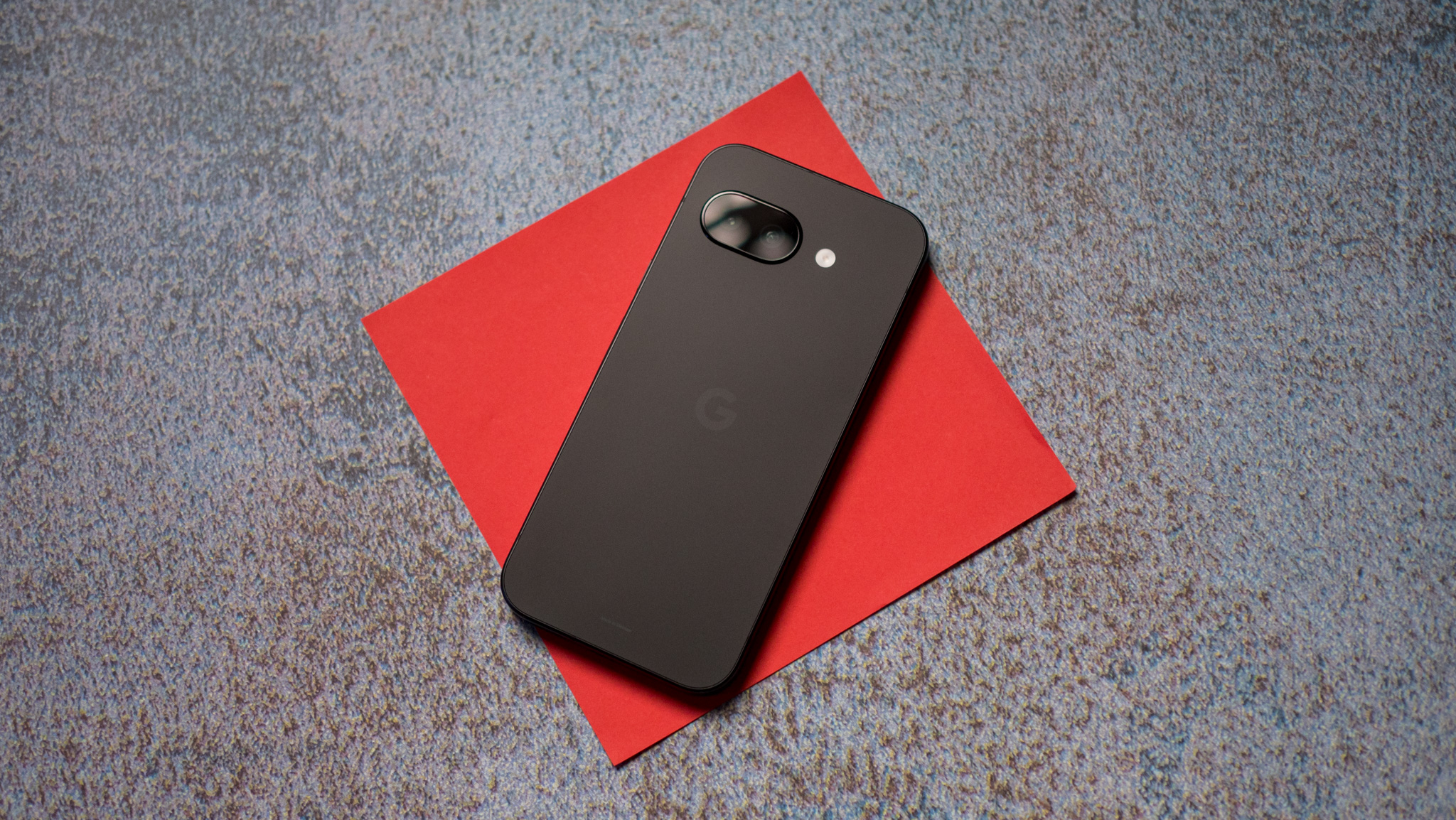 OnePlus 15R vs. Google Pixel 9a: Battle of the value phones Google Pixel 9a back on a red background