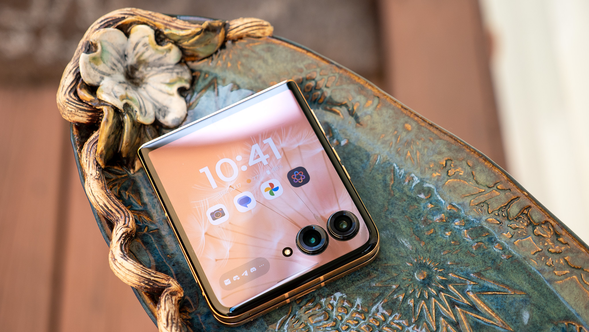 Το Motorola Razr Plus 2025 σε ένα φανταχτερό πιάτο με την οθόνη του καλύμματος φωτισμένη και ξεκλείδωτη