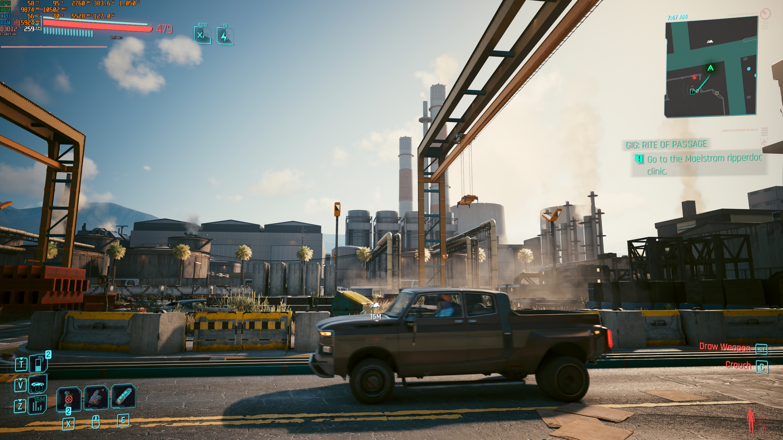 A scene from the game 'Cyberpunk 2077' shows a pickup truck driving past an industrial area with on-screen text indicating the task 'Go to the Maelstrom ripperdoc clinic.'