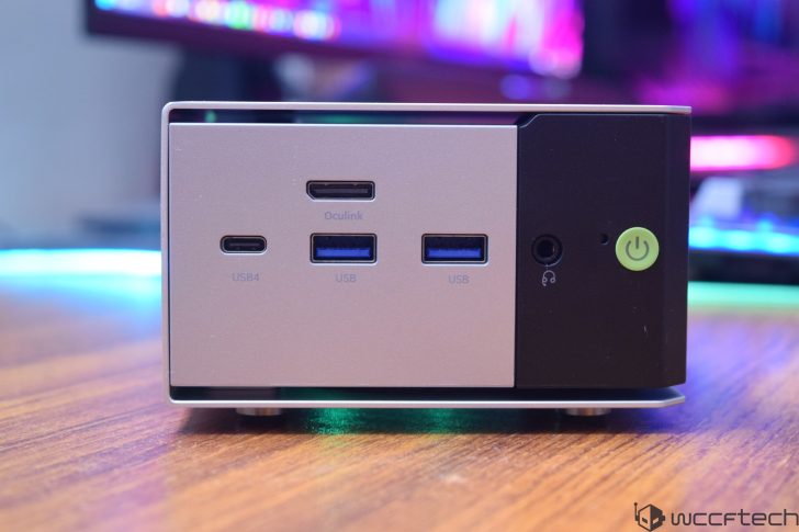 A compact computing device features front ports including 'USB4,' 'Oculink,' and two 'USB' with a power button and audio jack on the right.