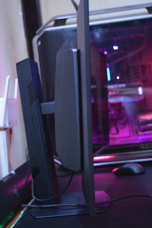 MSI MPG 341CQR X36 QD-OLED Gaming Monitor Review: Ultra-Wide Perfection With 360Hz A side view of a computer monitor with a thin black bezel next to a gaming PC featuring a visible NVIDIA RTX graphics card inside a case with purple lighting.