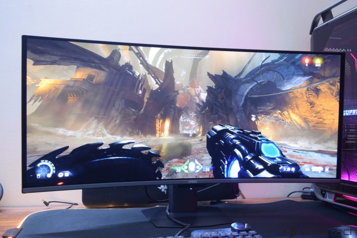 MSI MPG 341CQR X36 QD-OLED Gaming Monitor Review: Ultra-Wide Perfection With 360Hz A curved MSI monitor displays a scene from the game DOOM Eternal, with visible health and armor indicators.