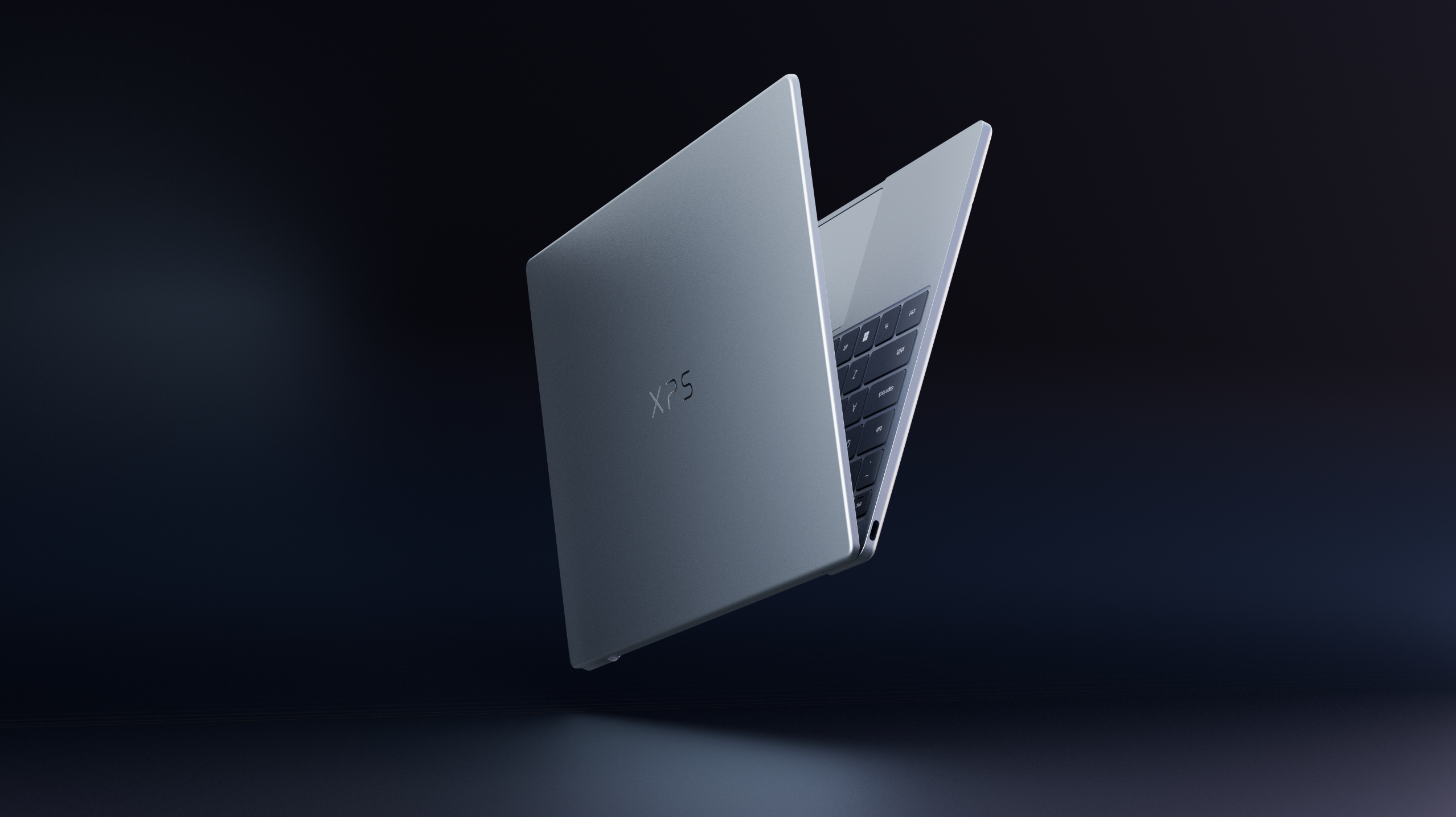 A floating Dell XPS laptop partially open against a dark background.