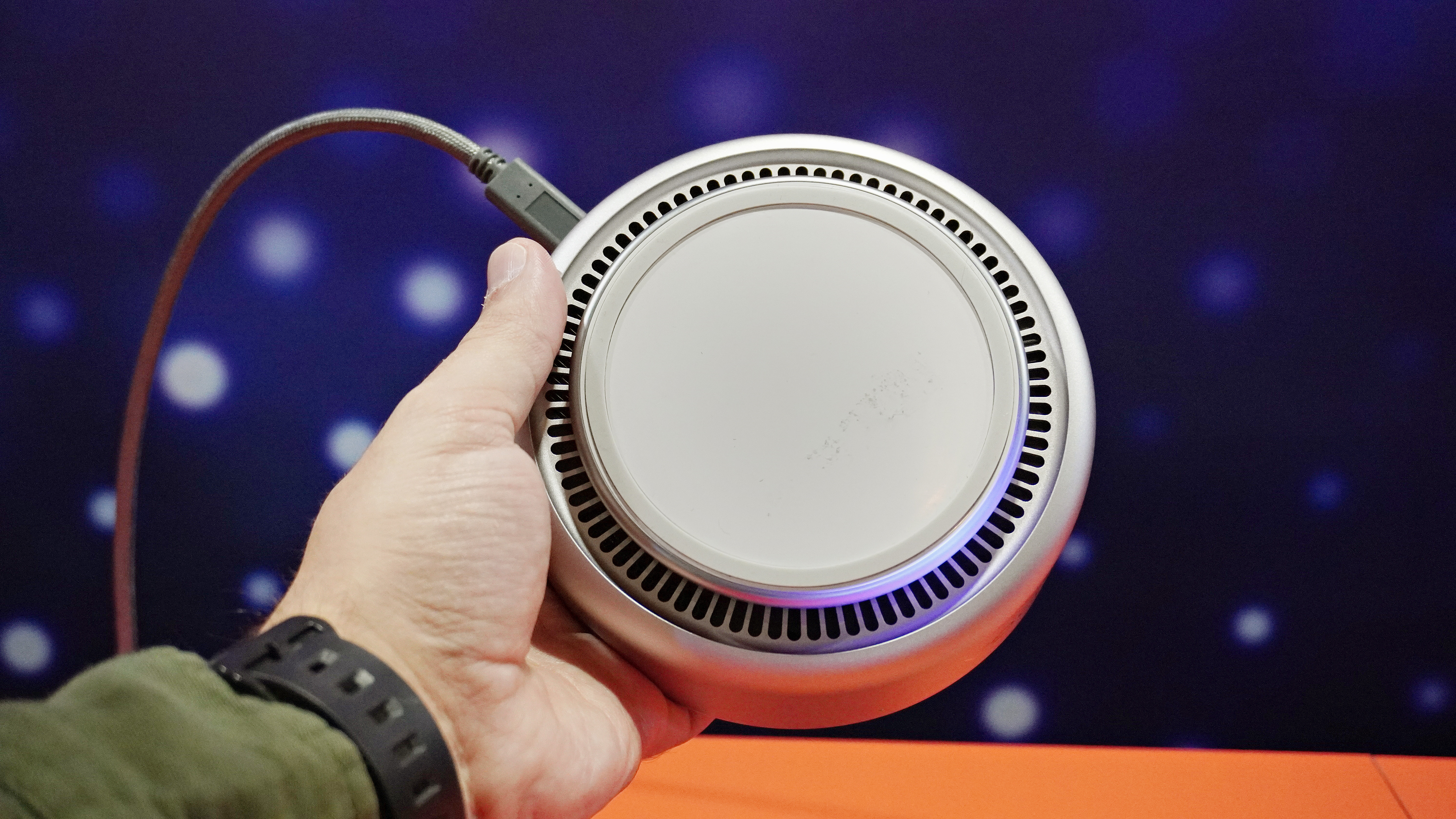 Ένα άτομο που κρατά το Lenovo Yoga Mini i δείχνει το κάτω μέρος αυτού του μίνι υπολογιστή