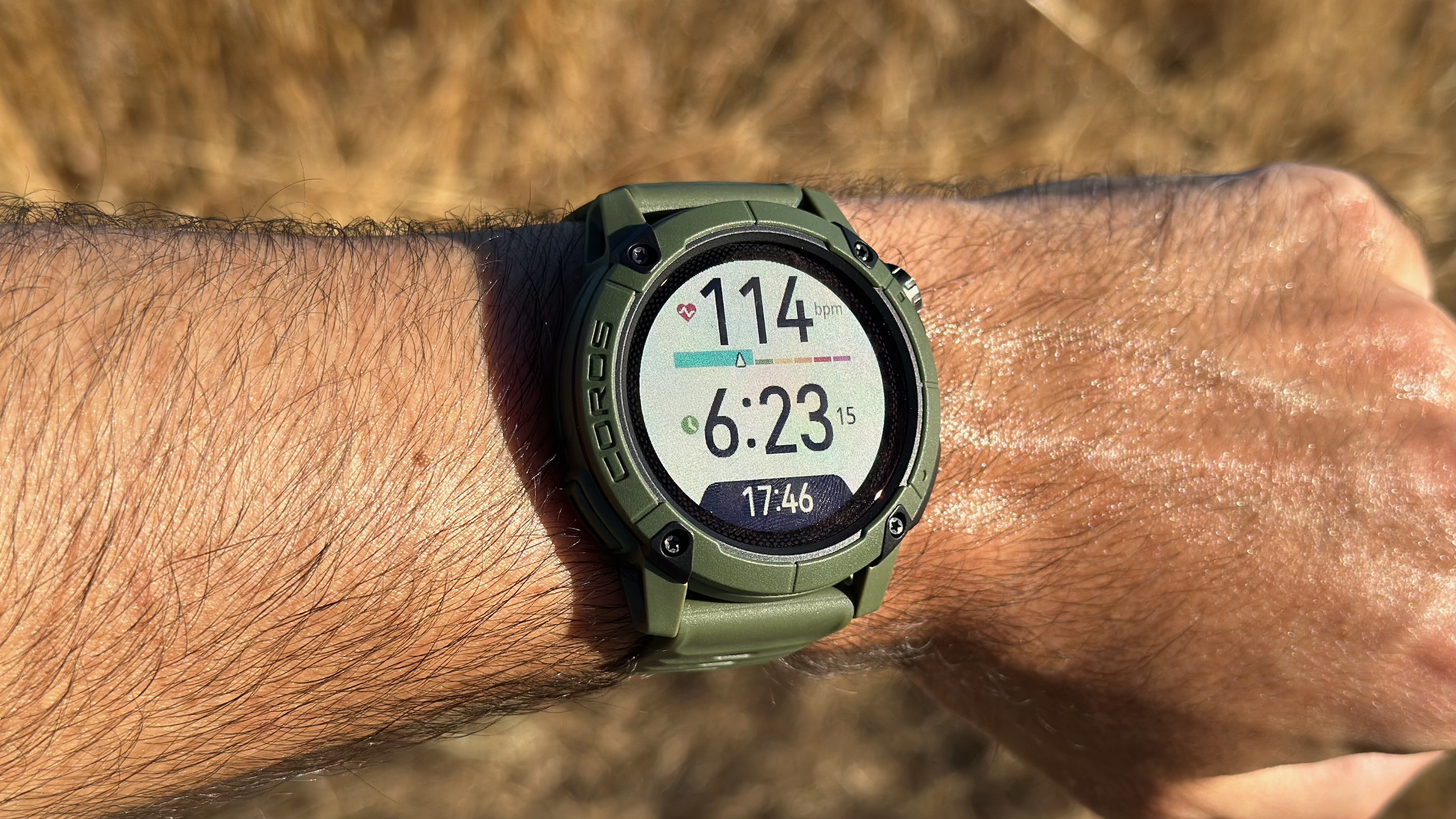 The COROS NOMAD watch showing a widget with the wearer's current heart rate and the time of day.
