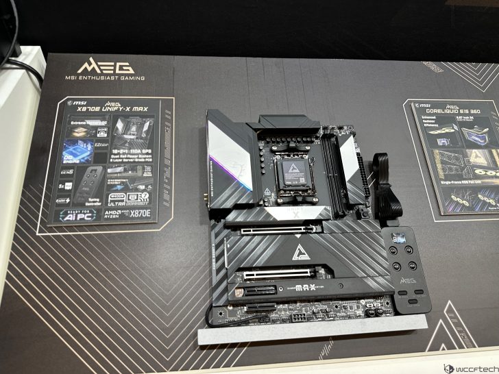 Μια μητρική MSI MEG X670E UNIFY-X MAX εμφανίζεται σε ένα επώνυμο χαλάκι δίπλα σε διαφημιστικά φυλλάδια.