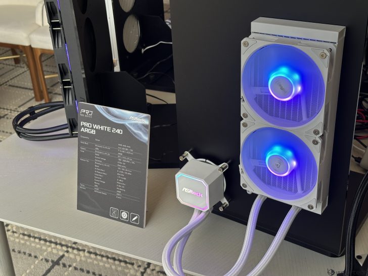An ASRock cooling system labeled 'PRO WHITE 240 ARGB' displays illuminated fans and a radiator setup on a desk next to specifications sheet.