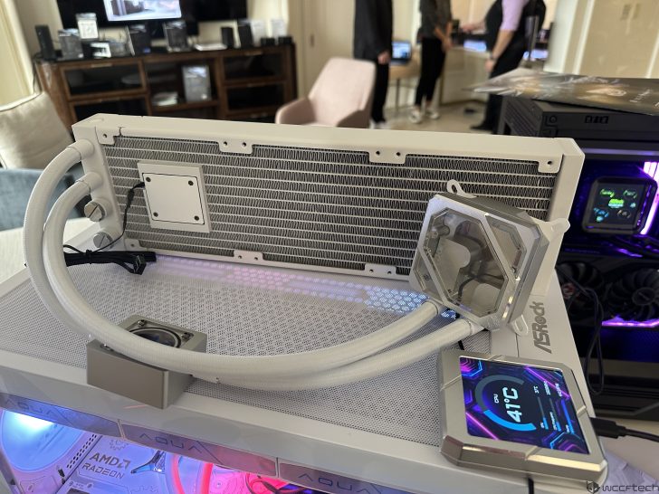 ASRock Aqua cooling system with a digital display showing '41°C' is showcased on a desktop setup, featuring visible AMD Radeon and Aqua branding.
