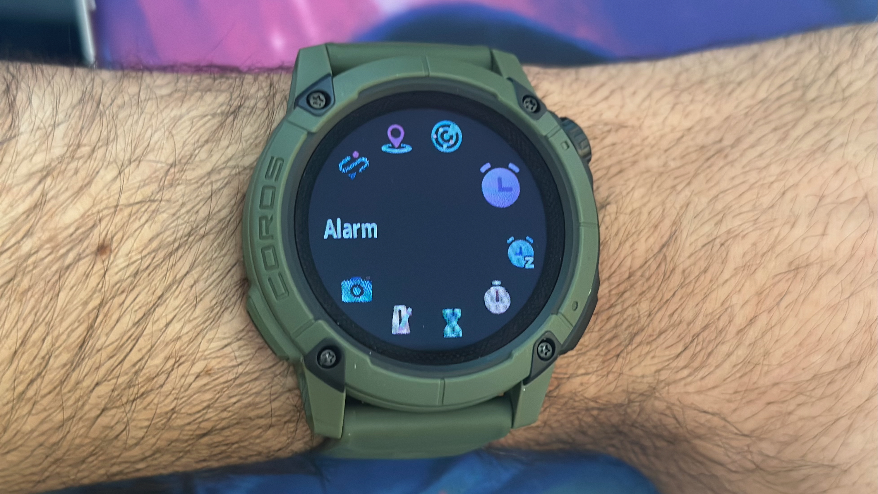 The COROS NOMAD's Toolbox menu showing various apps, with Alarm highlighted.