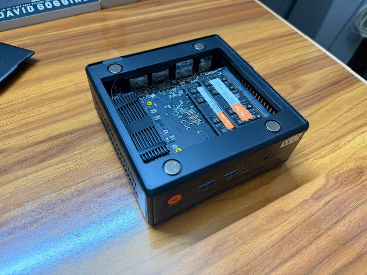 Ένας μίνι υπολογιστής Lenovo με το κάλυμμά του κλειστό αποκαλύπτει δύο PNY XLR8 SSD μέσα σε ένα ξύλινο γραφείο.