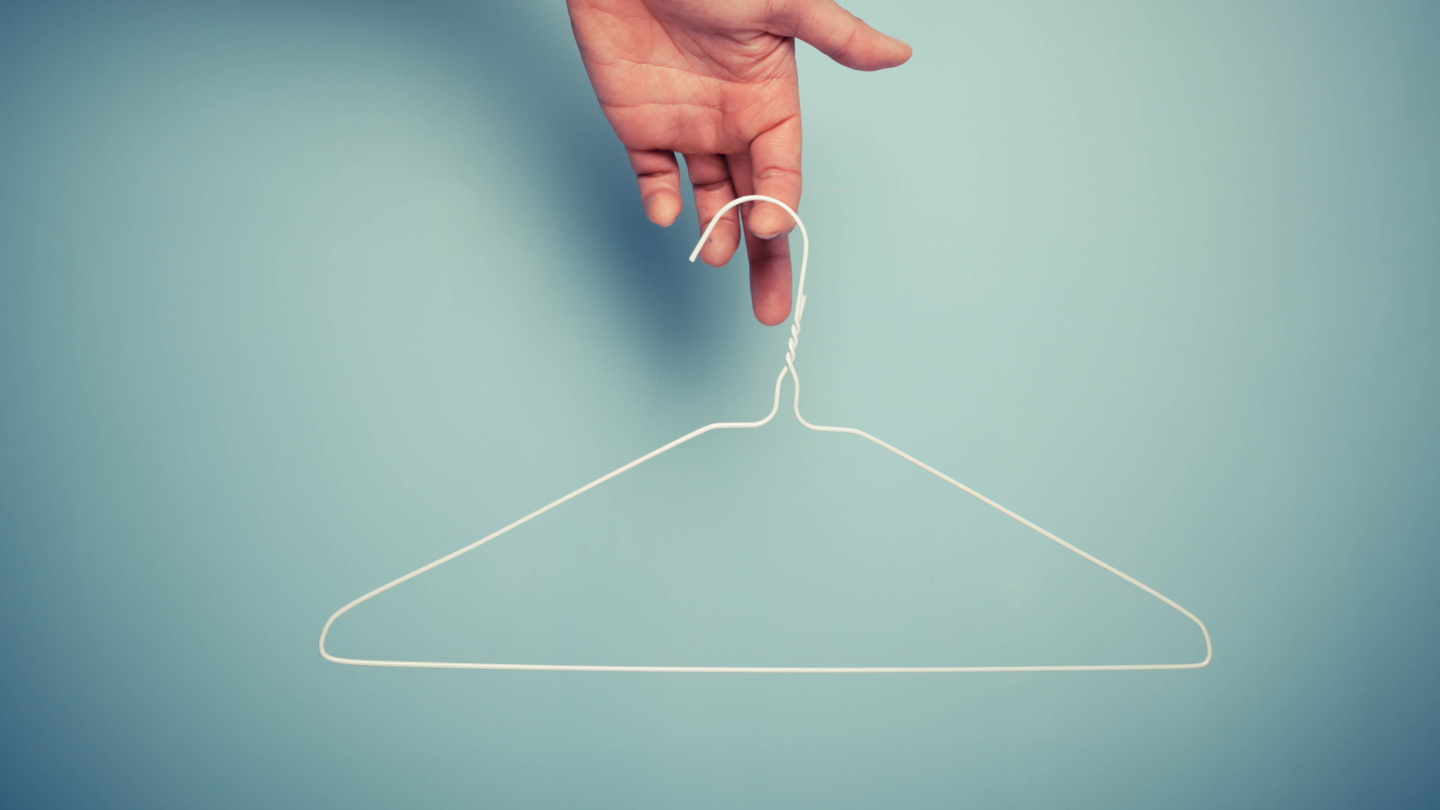 Κρατώντας μια λευκή συρμάτινη κρεμάστρα