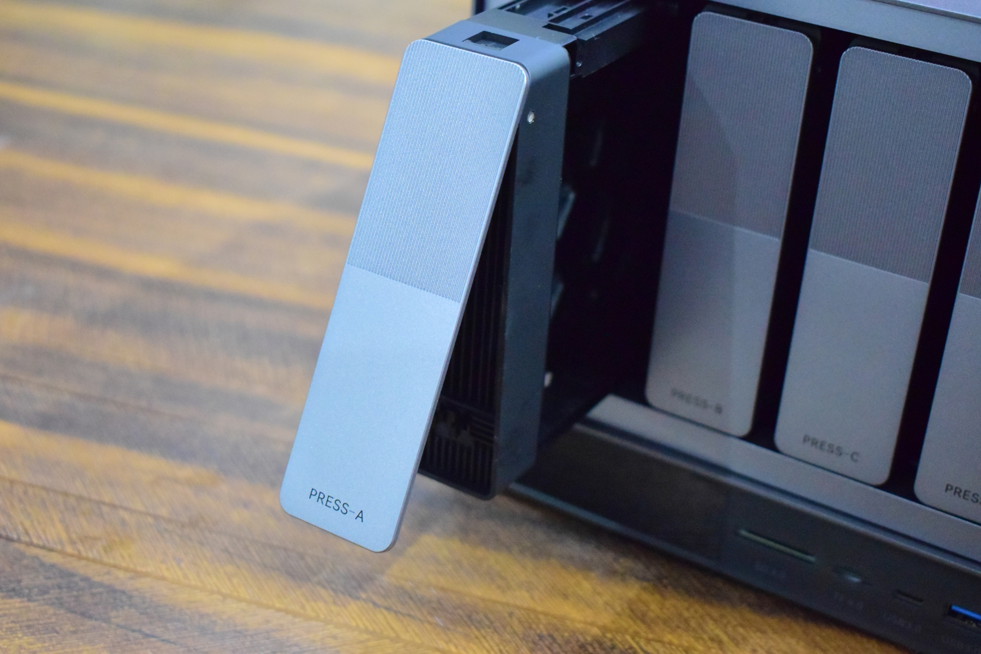 Zettlab D4 Review — A Convenient Budget AI NAS For Photographers And Content Creators A hard drive bay labeled 'PRESS-A' is partially open on a storage device.
