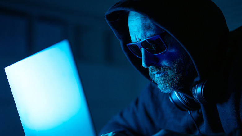 Ένας χάκερ που χρησιμοποιεί φορητό υπολογιστή για να χακάρει.