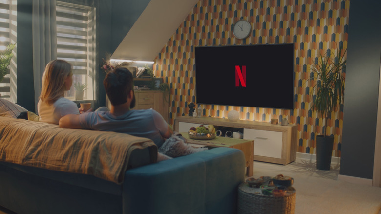 Ζευγάρι που βλέπει Netflix σε τηλεόραση στο σαλόνι