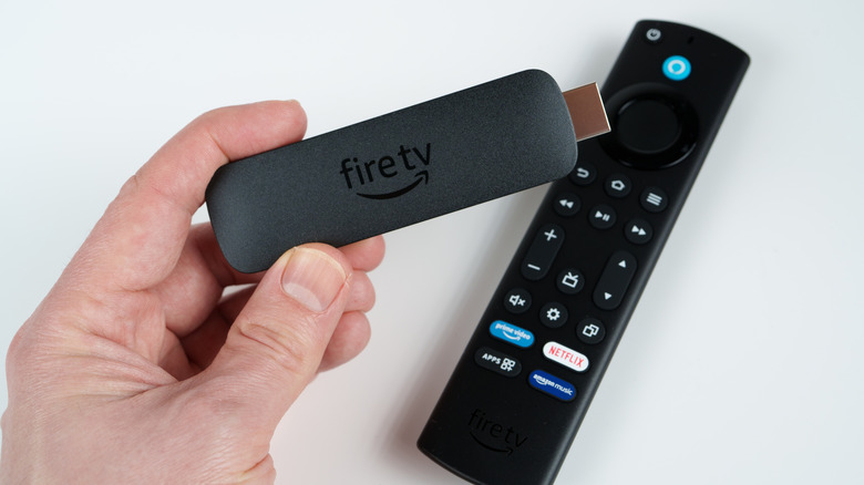 Ένα άτομο που κρατά ένα Amazon Fire TV Stick.