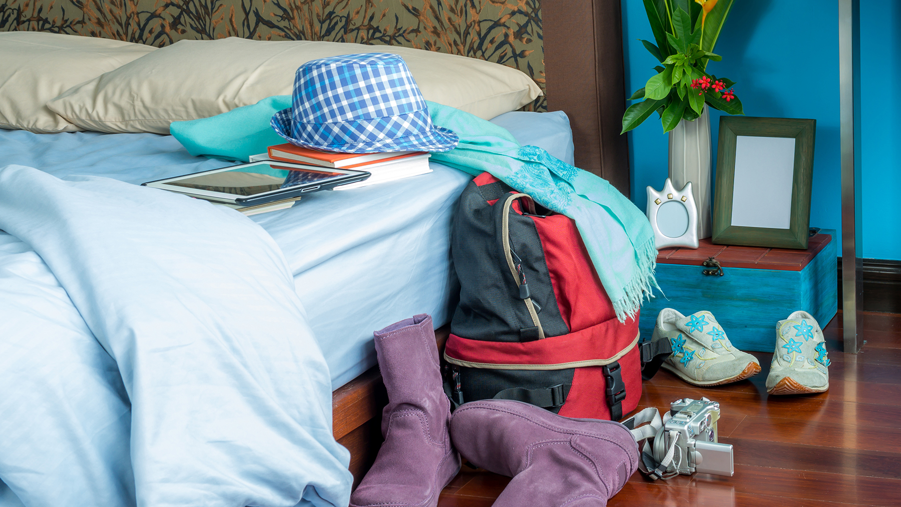 Ακατάστατη κρεβατοκάμαρα με άστρωτο κρεβάτι και τσάντα και ρούχα στο πάτωμα