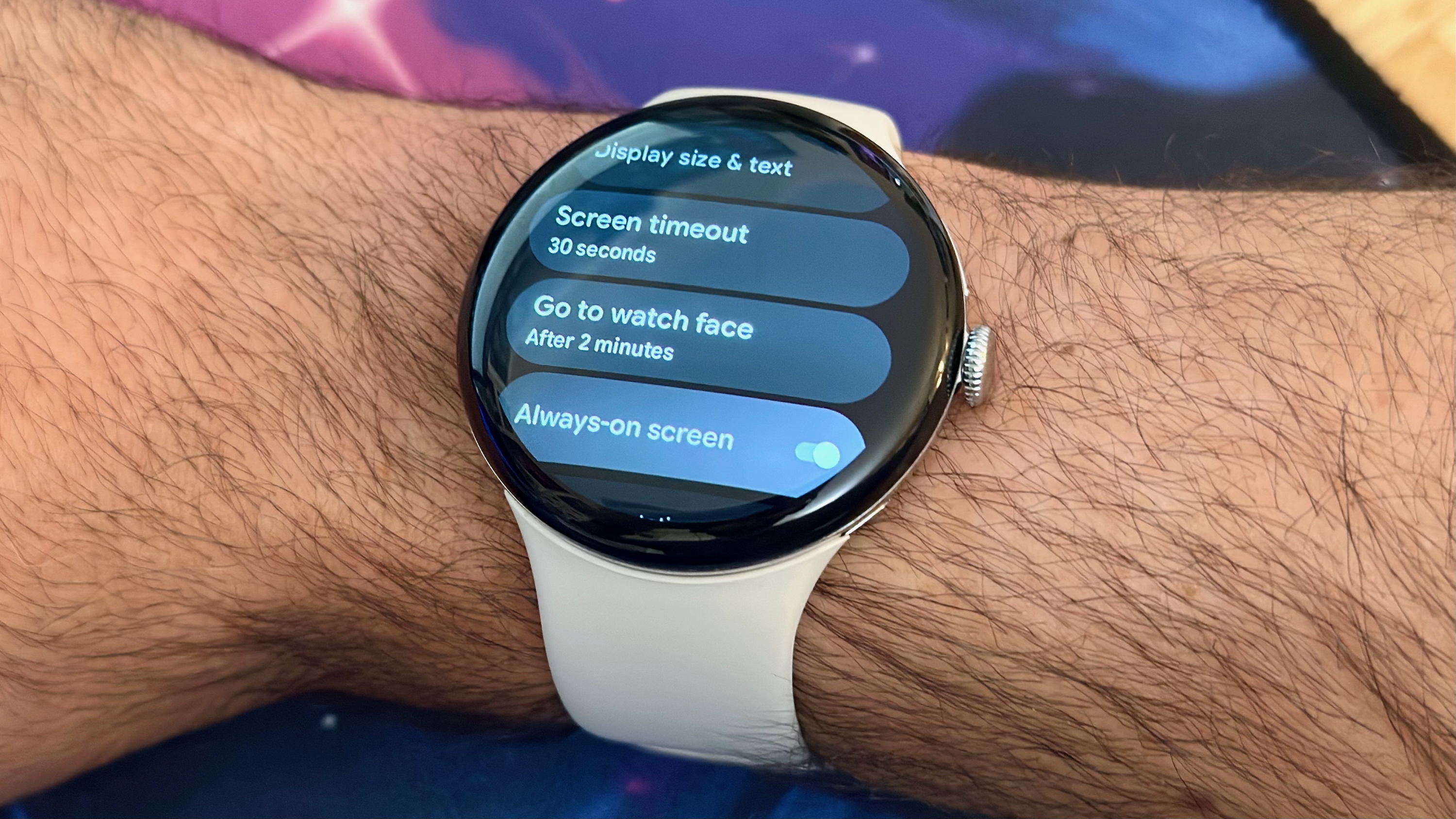 Μια φωτογραφία του Google Pixel Watch 4 στον καρπό, που δείχνει το μενού ρυθμίσεων οθόνης για το χρονικό όριο λήξης της οθόνης, "πηγαίνετε στο ρολόι" timeout και την οθόνη Always-on.