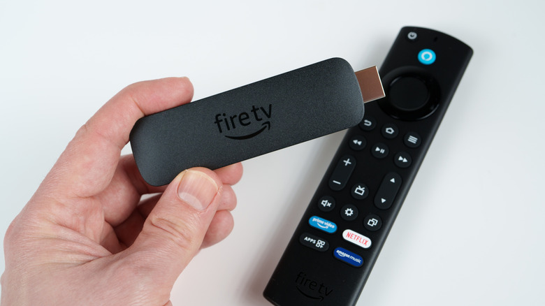 Ένα άτομο που κρατά ένα Amazon Fire TV Stick.
