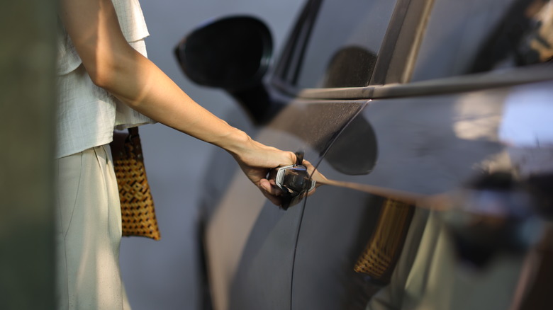 Μια γυναίκα που ανοίγει μια πόρτα αυτοκινήτου.