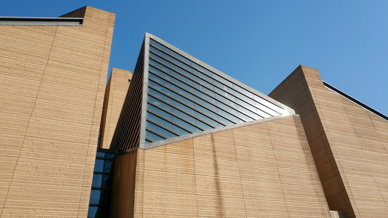 Χωματώδεις τοίχοι και μοντέρνα γυάλινα φωτιστικά από κοντά.