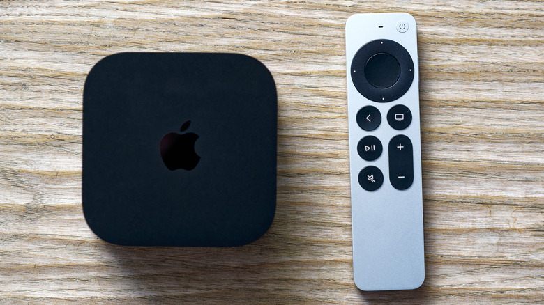 apple tv με τηλεχειριστήριο σε ξύλινη επιφάνεια