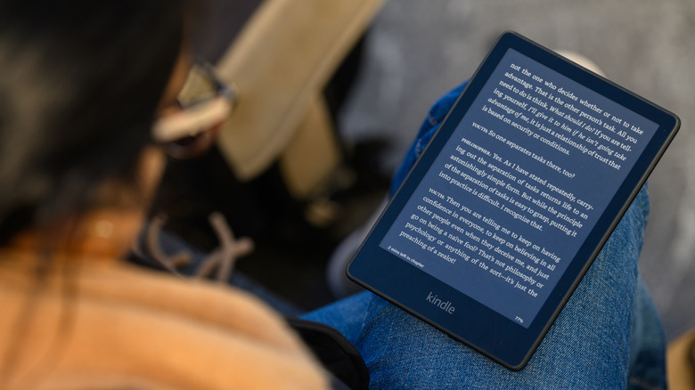 Ένα άτομο που διαβάζει ένα Kindle στην αγκαλιά του