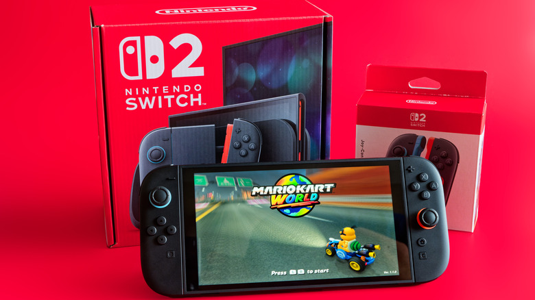 Το Nintendo Switch 2 μπροστά από τη συσκευασία του σε κόκκινο φόντο